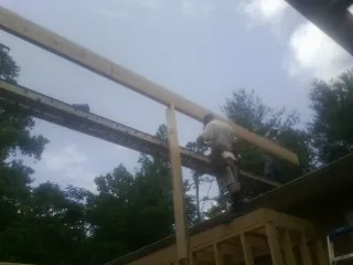 Carpenter setting a ridge beam over a new addition frame — Ice Dam Removal by Roofing Brothers in Gervais