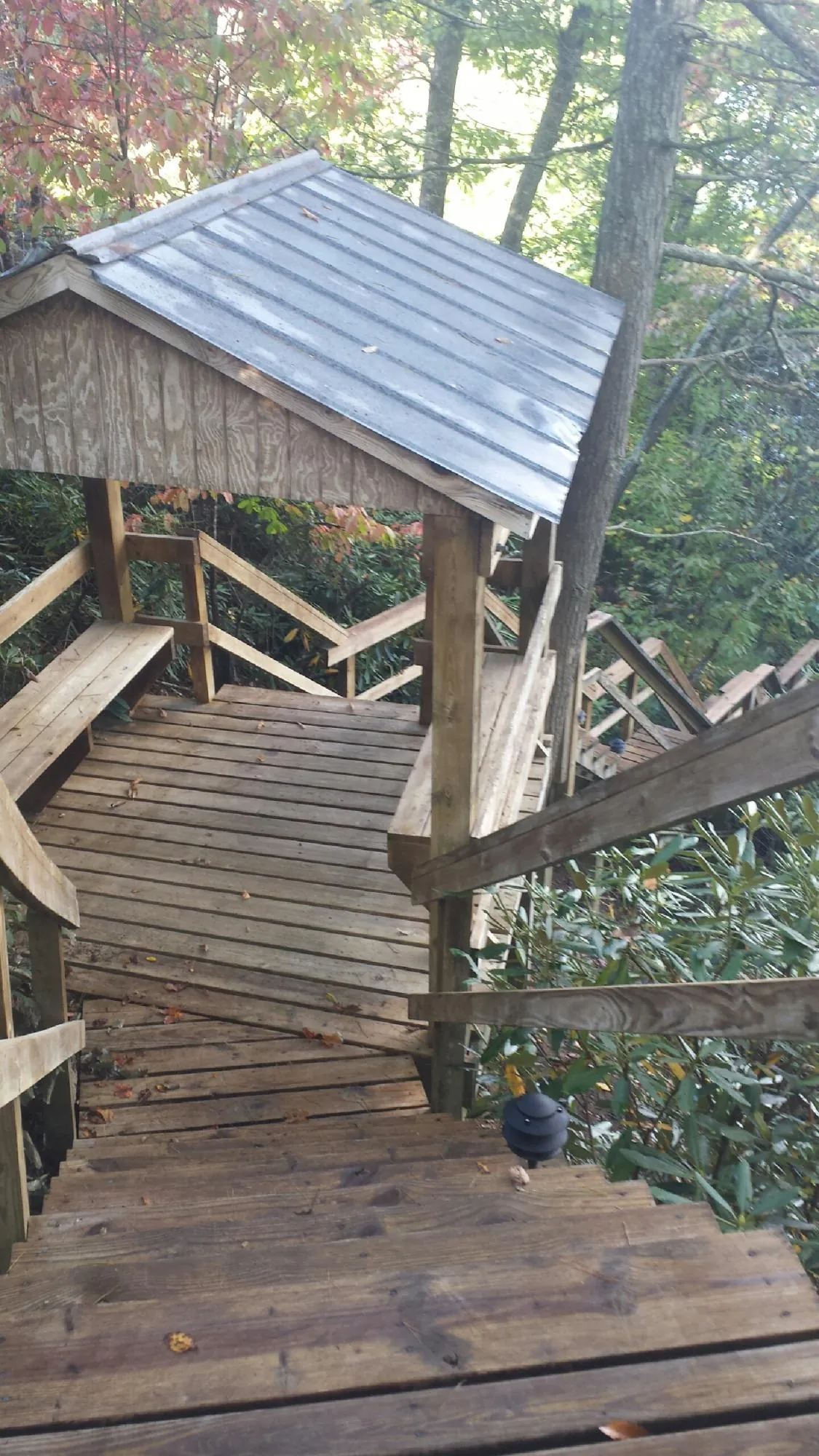Metal roofed shelter over wooden steps on a wooded walkway — Skylight Repair & Installation work by our crew in Gervais