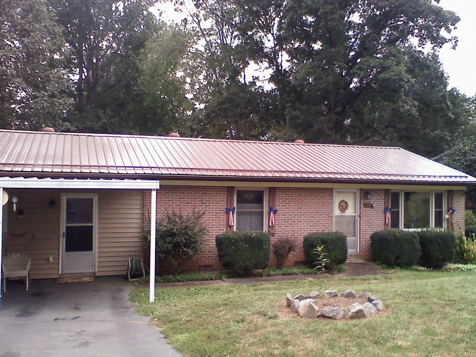Bronze metal roof and carport on a brick ranch home — Roof Repair work by our crew in Gervais